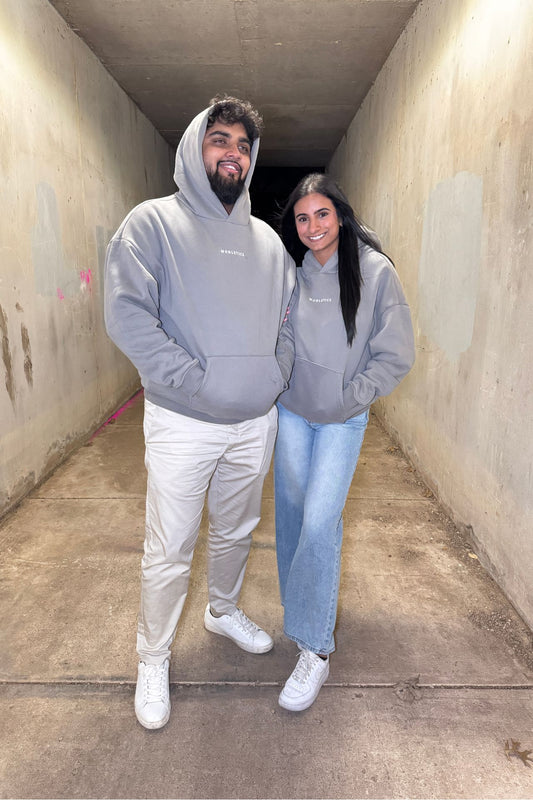 Fogline Hoodie Men & Women in light gray worn by male and female models, showcasing thick fabric and minimalist silicone 3D logo design.